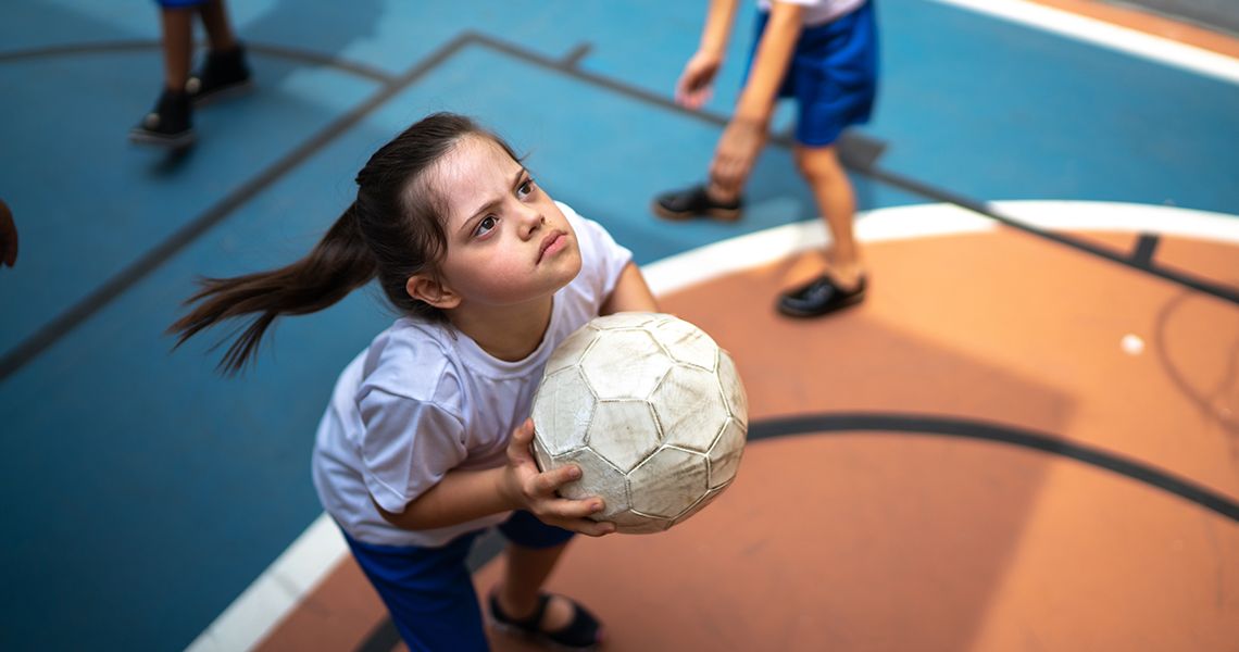 Focused student with disability playing basketball