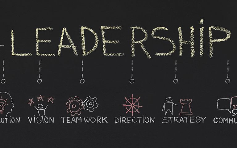 Chalkboard style writing of the word "Leadership" with lines coming off of it into different elements of leadership