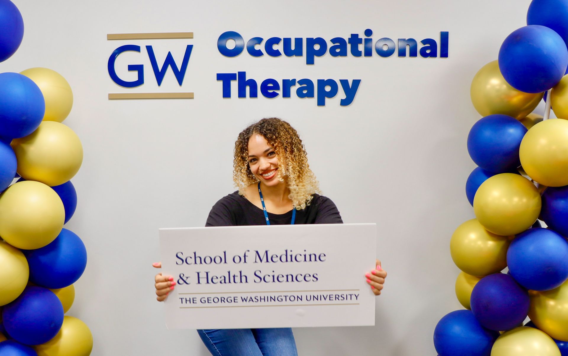 admissions officer holding GW SMHS sign
