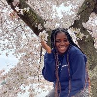 Collese Daley in front of cherry blossoms