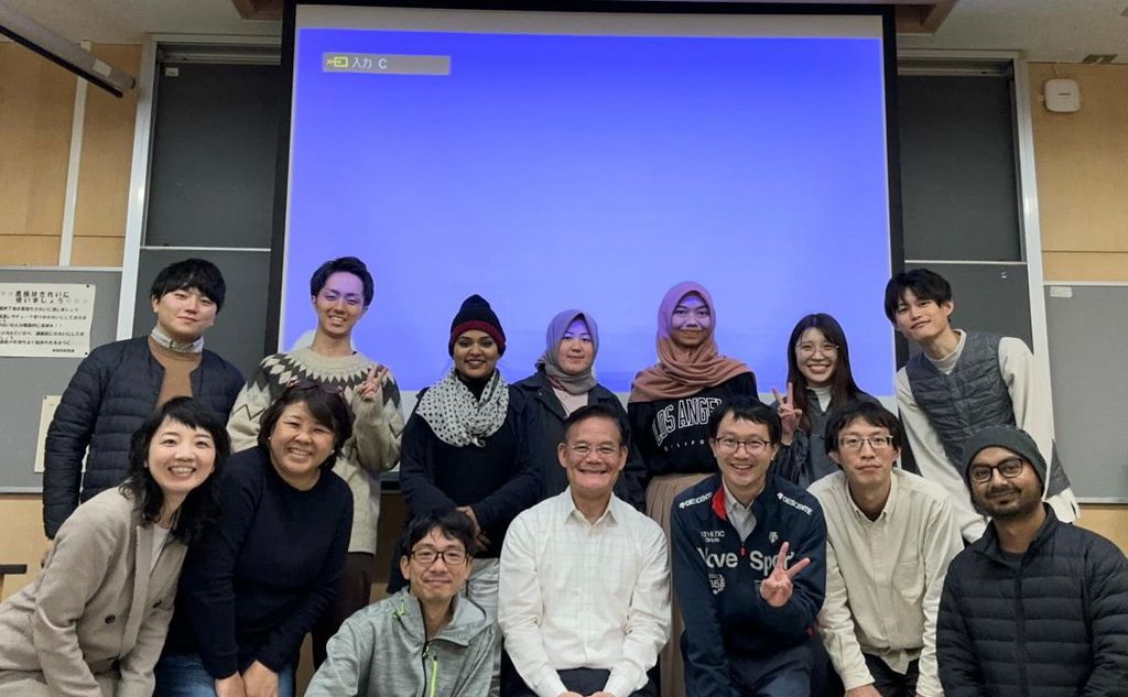 Roger Ideishi in Tokyo with group of students sitting in front of blue screen