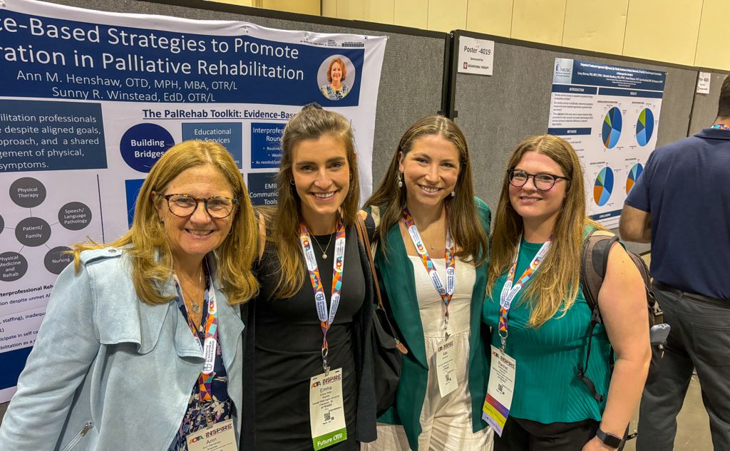 Faculty member presenting poster smiling with three students at AOTA Conference 2024