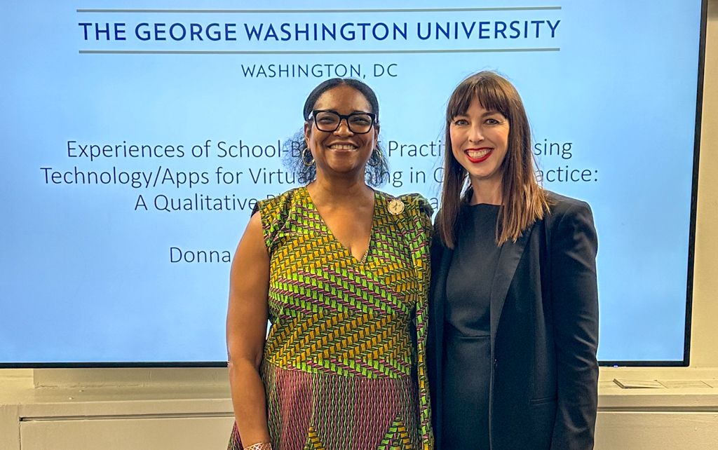 GW OT Faculty Sarah Doerrer with pOTD Graduate Donna-Ann Spence in front of presentation