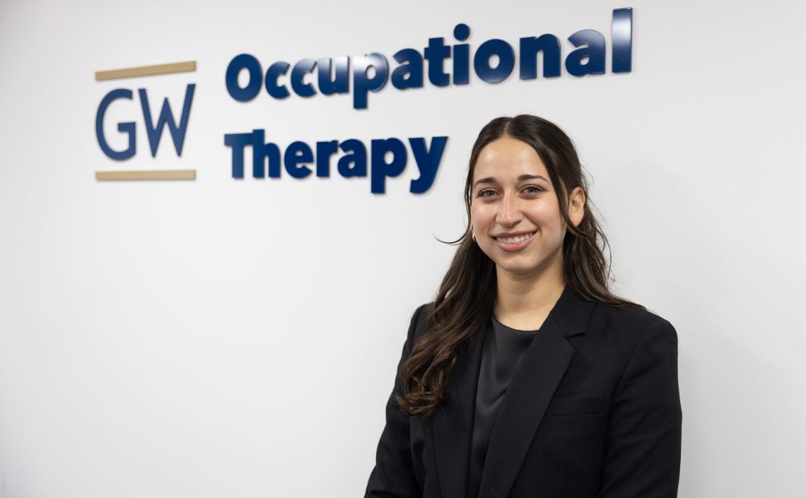 Natalia Anzaldúa Ayala in front of GW OT sign