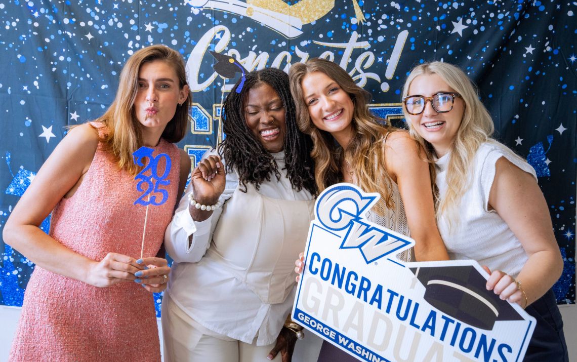 GW OTD Graduates Smiling with Photo Props