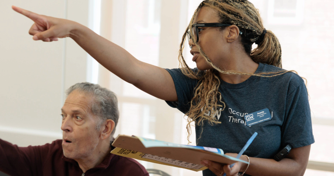 OT student pointing to direct older adult at Falls Prevention Awareness Day