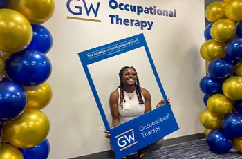 GW eOTD Student holding Picture Frame that says GW Occupational Therapy