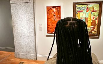 Quenita Simms looking at art by Daniel Pressley, The Soprano at the Mourning Easter Wake of 1968